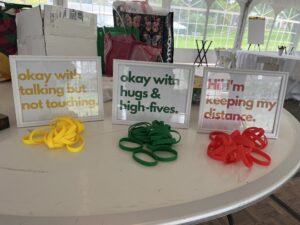 a table with yellow, green and red wristbands with signs indicating levels of covid risk tolerance for wearers
